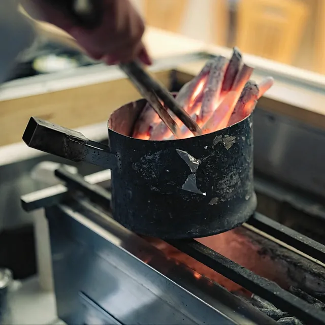 焼鳥 鈴音の焼き台に炭を入れる手元