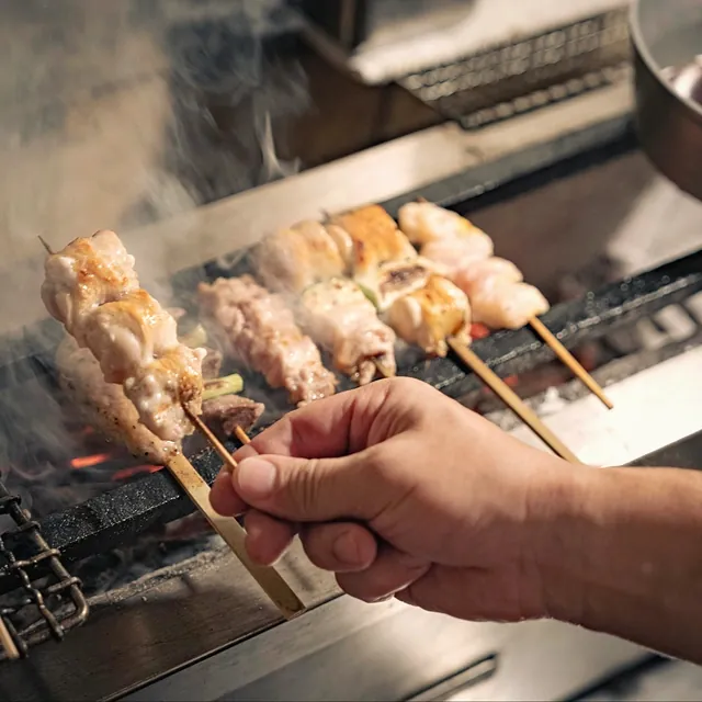 焼鳥 鈴音の焼き台から串を取る手元