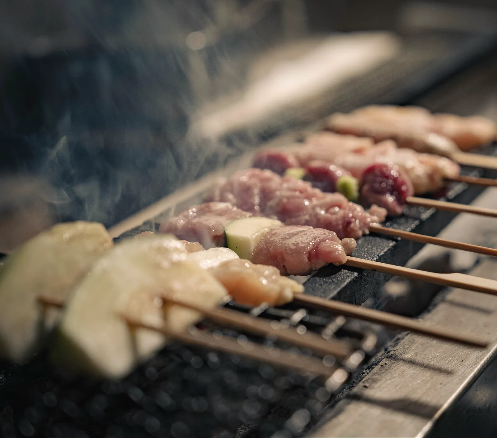 焼鳥 鈴音の煙の立つ焼き台と串