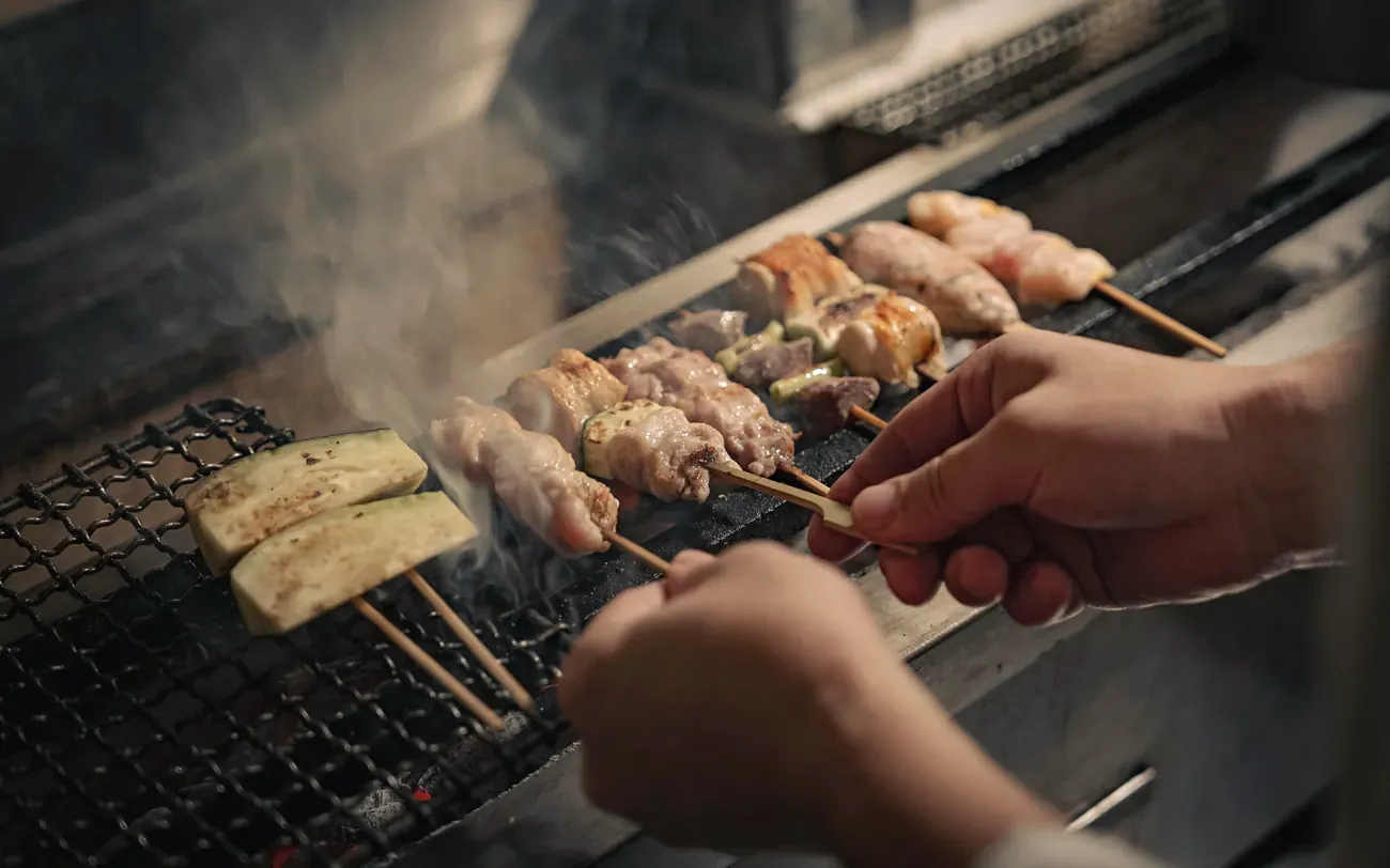焼鳥 鈴音の焼き台で串を返す手元